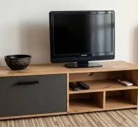 A television on wooden furniture with a wood-patterned floor in a studio apartment.