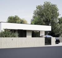 A family house in Nesvady with a white facade, a concrete fence, and lush greenery.