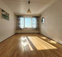 A bright room with a large window, curtains, and a wooden decor floor in a 2-room apartment.