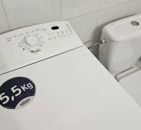 A washing machine next to the toilet in a studio apartment, suitable for everyday use.