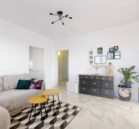 Living room with a sofa and decorative furniture in a three-room apartment, floor with wooden decor.