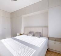 Bedroom in a 3-room apartment with wood-patterned flooring and built-in wardrobes.