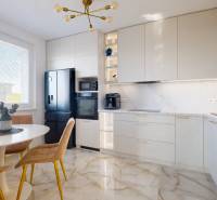 A kitchen in a 3-room apartment with a marble floor and elegant cabinets.