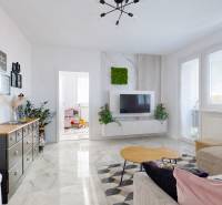 Living room in a 3-room apartment with a decorative table and a television on the wall.