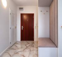 Entrance hall with light walls, brown doors, and shiny floor in a 3-room apartment.