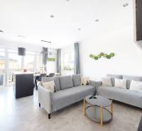 Living room in a three-room apartment with a wooden decor floor and gray sofas.