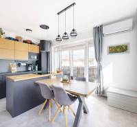 A kitchen in a 3-room apartment with a wood-patterned floor, a dining table, and modern air conditioning.