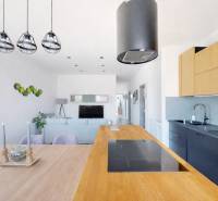 A kitchen in a 3-room apartment with a wooden decor floor and pendant lights.