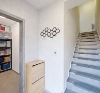 A hallway with storage spaces and a staircase in a 3-room apartment, flooring with a wood decor.