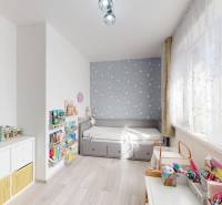 Children's room with a bed, cabinet, toys, and books in a 3-room apartment. Floor with wooden decor.