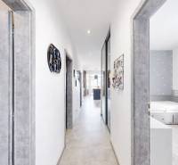 A hallway in a 3-room apartment with white walls, gray doors, and a light floor.