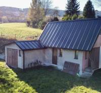 A family house in Šarišské Čierne with a green garden and a metal roof.