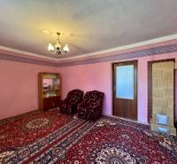 A room in a family house with pink walls, heating, and a red carpet.