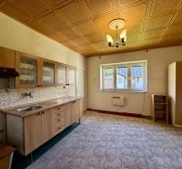 A kitchen with wooden cabinets and patterned tiles in a family house.