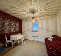 Interior of a family house with wooden paneling and a floral painting on the wall.