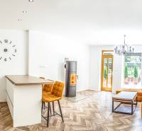 Bright holiday apartment with a kitchen, orange sofa, and wood-patterned flooring.
