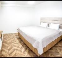Bedroom in a holiday apartment with a bed and wooden decor flooring.