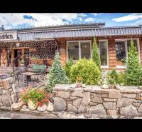 Stone facade of a Holiday Apartment in Štrba with a terrace and floral decoration.