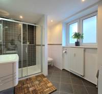 Bathroom in a 2-room apartment with a spacious shower and ceramic tiles.