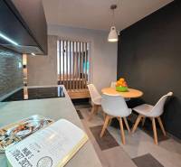 Dining area with a table and chairs in a 2-room apartment, floor with wooden decor.