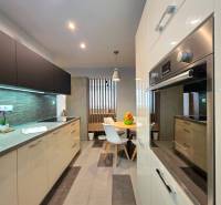 A kitchen in a 2-room apartment with a dining area and modern kitchen appliances.