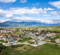 A view of family houses in Dolný Kalník with a mountain panorama in the background.