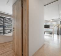 Interior of a family house with a bathtub, wooden decor flooring, and a bright living room.
