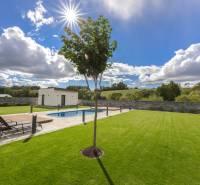 A family house in Dolný Kalník with a swimming pool, green lawn, and relaxation zone.