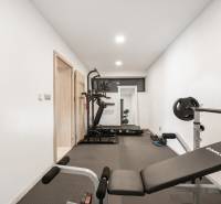 Home gym interior with a treadmill and weight benches in a family house.