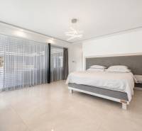 Elegant bedroom with a large window and a bed in a family house.