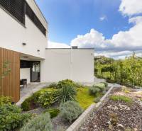 A garden at a family house in Dolný Kalník with modern architecture and landscaped greenery.