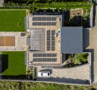 Aerial view of a family house in Dolný Kalník with solar panels and a lawn.