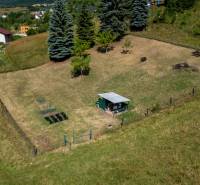 A plot in Banská Belá designated for living, with a gazebo and a garden in a natural environment.