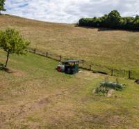 Hilly terrain in Banská Belá designated for residential plots with young trees and a garden.