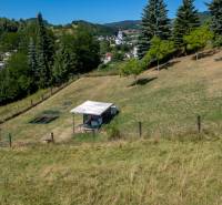A garden in Banská Belá with a gazebo on a slope, suitable for residential plots.