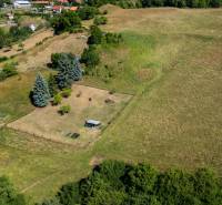 Aerial view of residential plots in Banská Belá with surrounding houses and greenery.