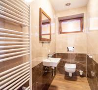 A bathroom in a family house with a wooden decor floor, a sink, and a heating element.