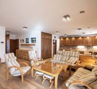 Interior of a family house with a spacious living room, kitchen unit, and wooden decor flooring.