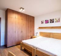 A bedroom with wooden furniture and a floor with a wooden decor in a family house.