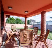 The terrace of a family house on Krajná Street in Stupava with wooden furniture and brick walls.