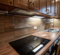 A kitchen in a family house with a wooden decor floor and a wooden kitchen unit.