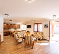 Living room with dining area and kitchen, wooden decor flooring, family house.