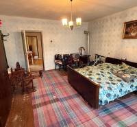 A room in a family house with a traditional bed, wardrobe, and bicycle.