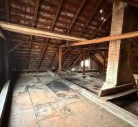 Attic in a family house with wooden beams and a large window.