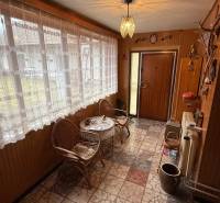 Entrance hall in a family house with rattan chairs and large windows.