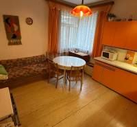 Interior of a family house with a retro kitchen, round table, and sofa.