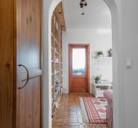 Living room of a 4-room apartment with a patterned carpet, a swinging chandelier, and wooden doors.