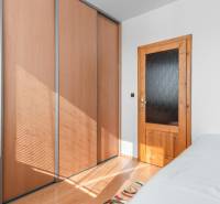 Bedroom with a wardrobe and wooden door in a 4-room apartment with a wood-decor floor.