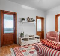 Living room in a 4-room apartment with red striped armchairs and a shelf on the wall.