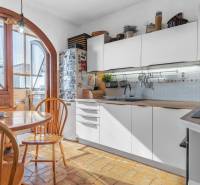 A kitchen in a 4-room apartment with wooden decor, an arched window, and a dining table.